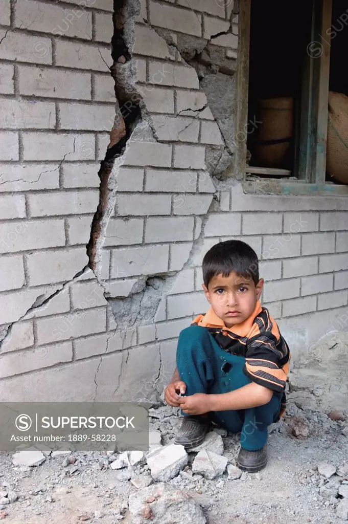 Little boy playing with cracked wall