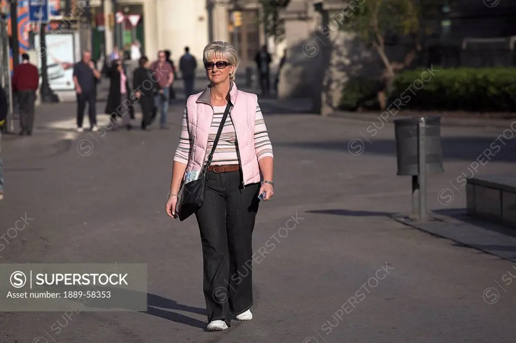 Woman walking up La Rambla, Barcelona, Spain
