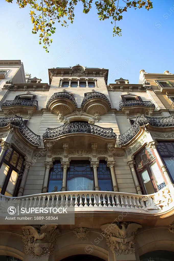 Low angle view of ornate balconies, Barcelona, Spain