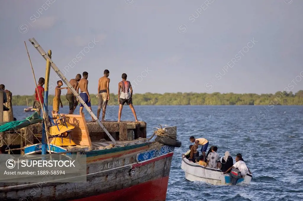 Young boys jumping into the sea by the jetty at Lamu, Kenya, East Africa