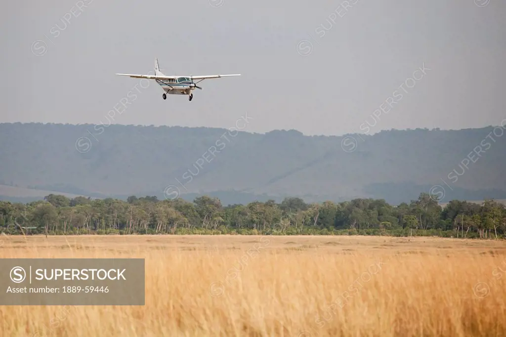 Airplane over field, Kenya, Africa