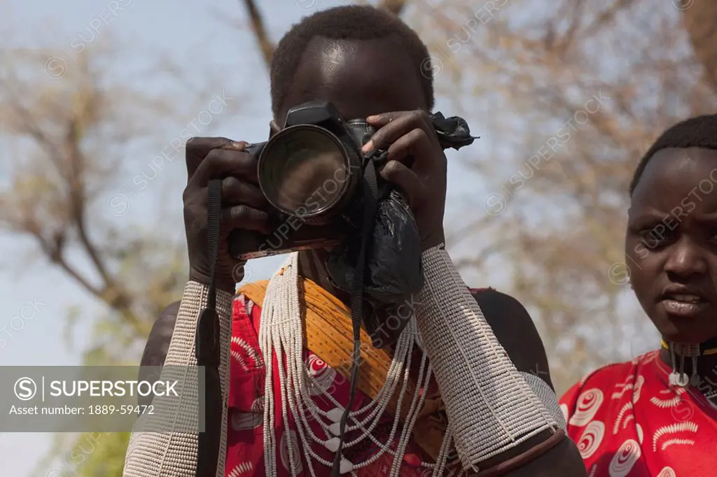Woman from Shompole Maasai Tribe looking through a camera, Kenya, Africa