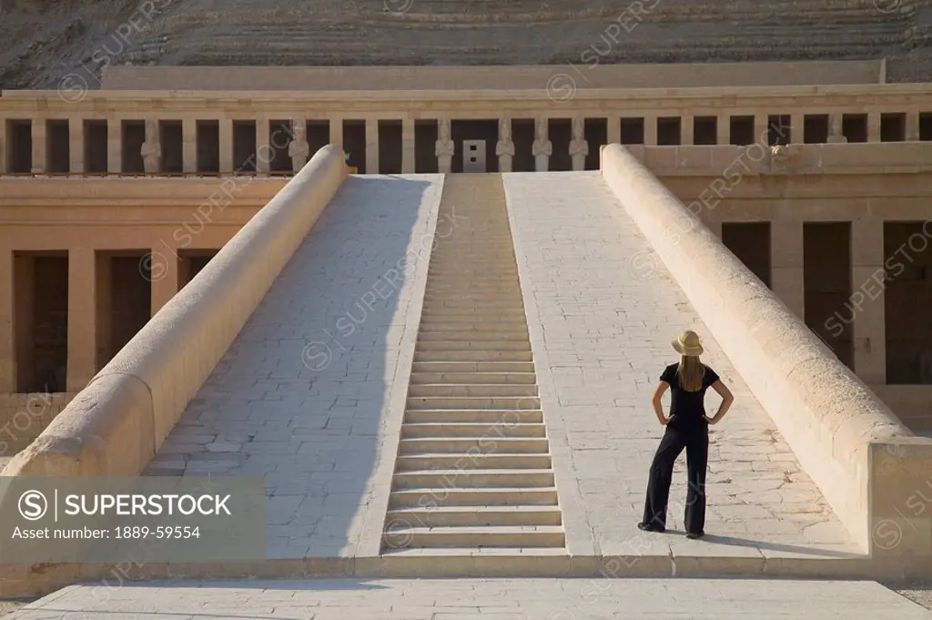 Woman tourist gazes at the Temple of Hatshepsut, Luxor, Nile Valley, Egypt