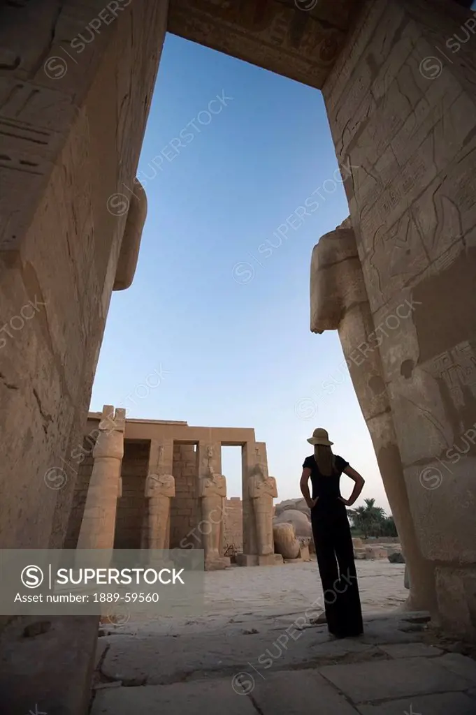 Woman tourist gazes at the Ramesseum, Luxor, Nile Valley, Egypt