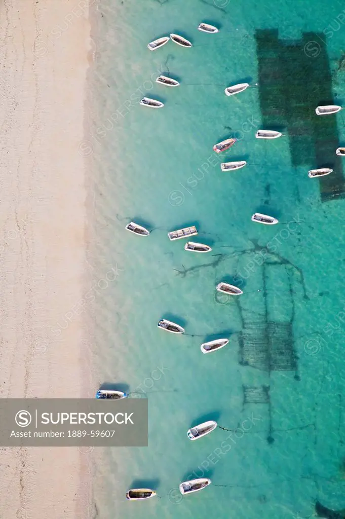 Aerial view of rowboats in tropical waters next to pristine sandy beach, Bali, Indonesia