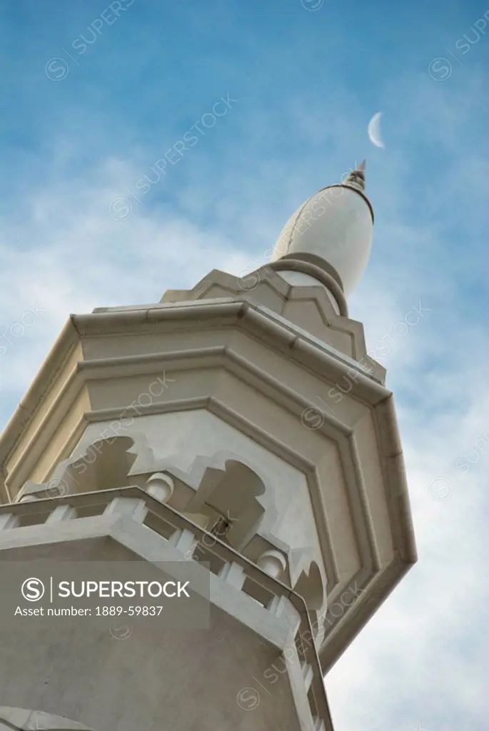 Kuala Lumpur, Malaysia, A Tower With An Ornate Facade With The Moon In The Sky