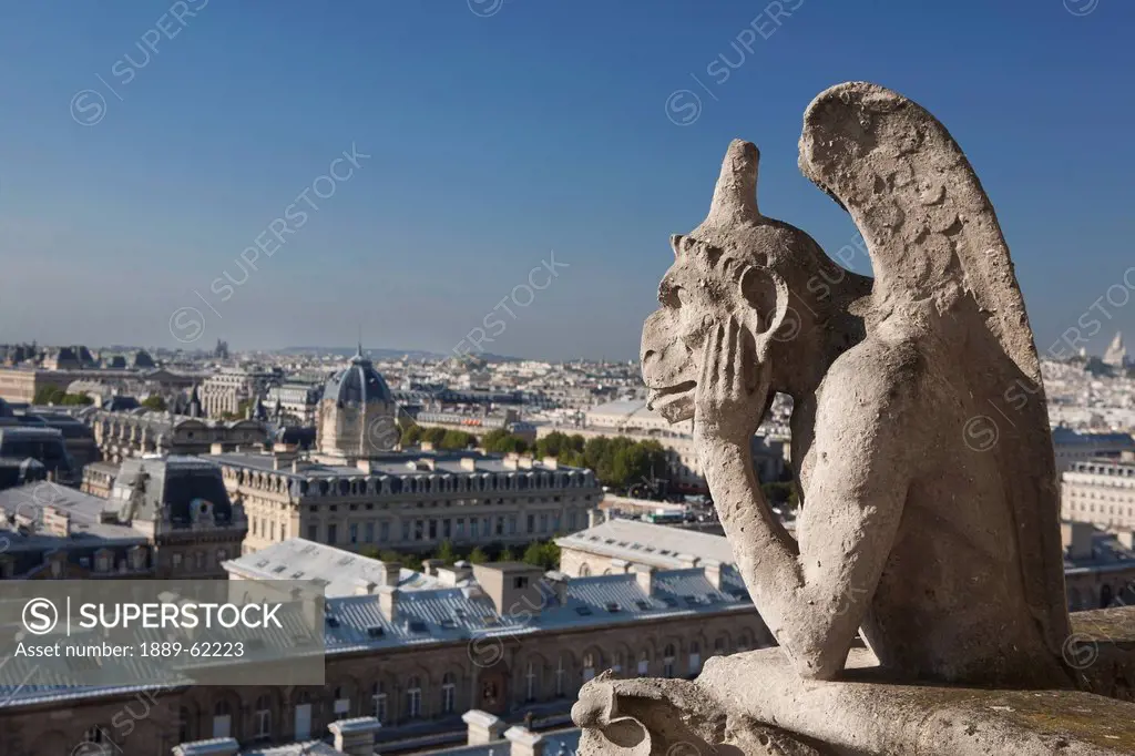 gargoyle overlooking paris with it´s tongue sticking out, paris, france