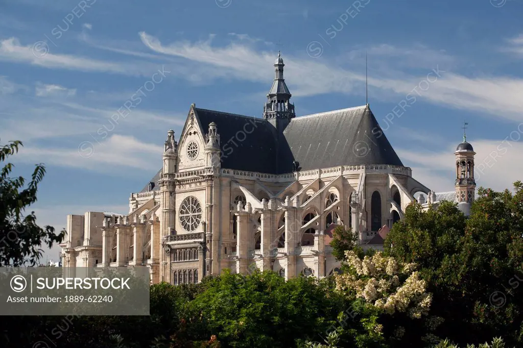 large church surrounded by trees with blue sky and clouds, paris, france