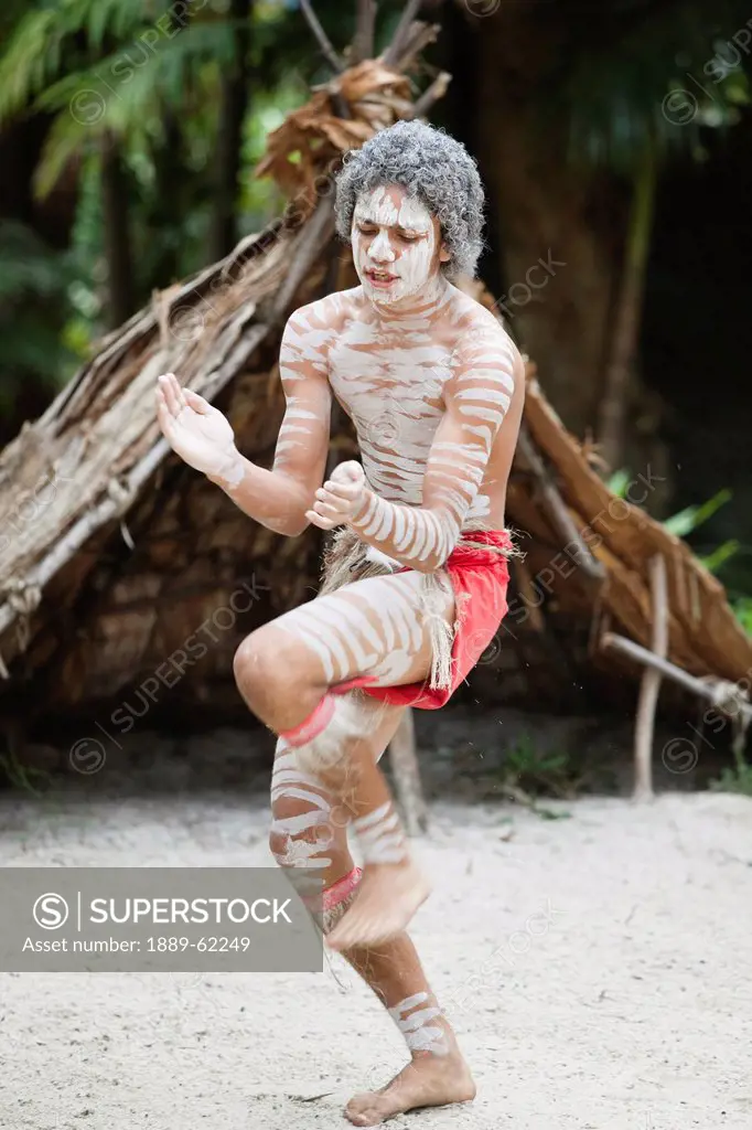 an indigenous man dancing on the sand, queensland, australia