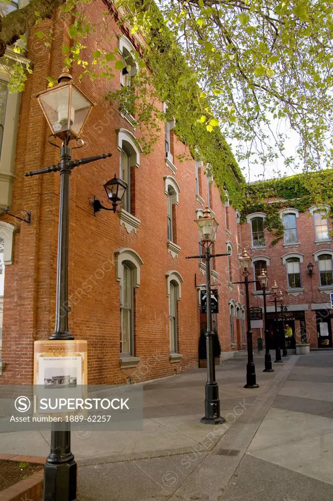 a brick building with windows and light posts along the sidewalk, victoria, british columbia, canada