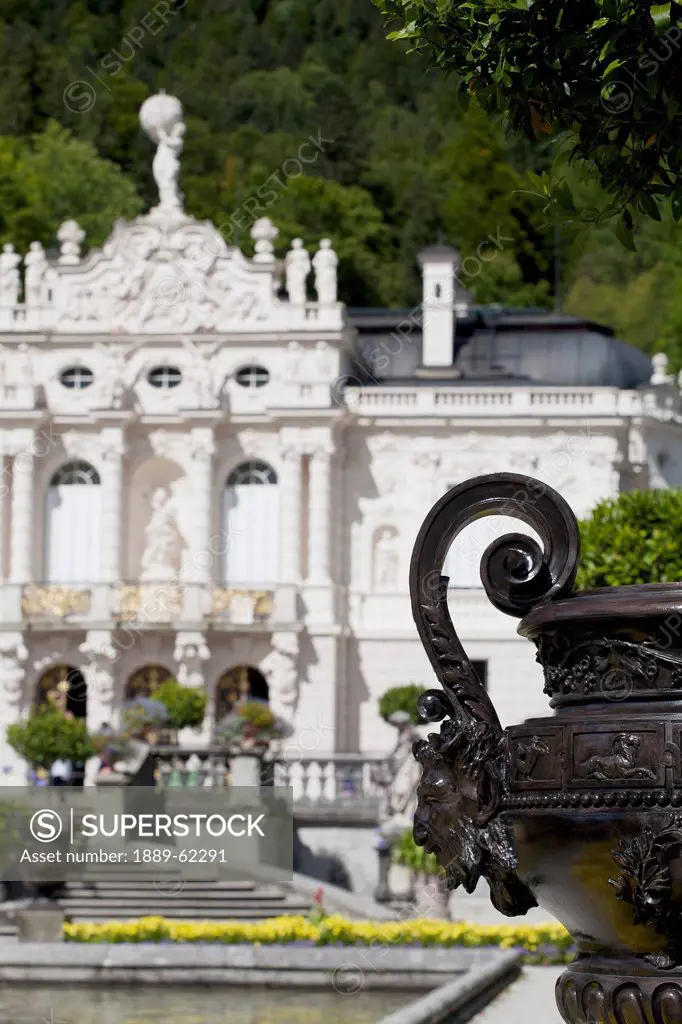 curled handle with a face on a vase with a white castle in the background, linderhof, germany