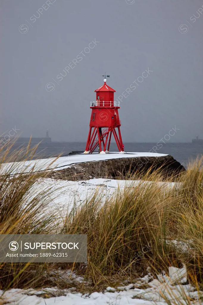 a red lighthouse along the coast, south shields, tyne and wear, england