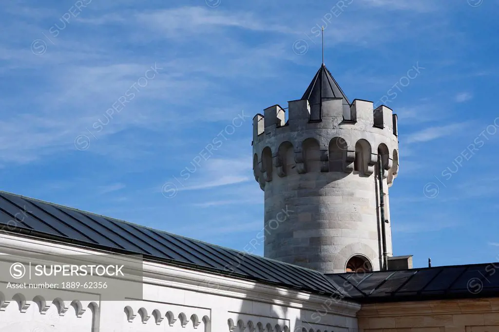round tower of a castle with a turret against a blue sky, fussen, germany