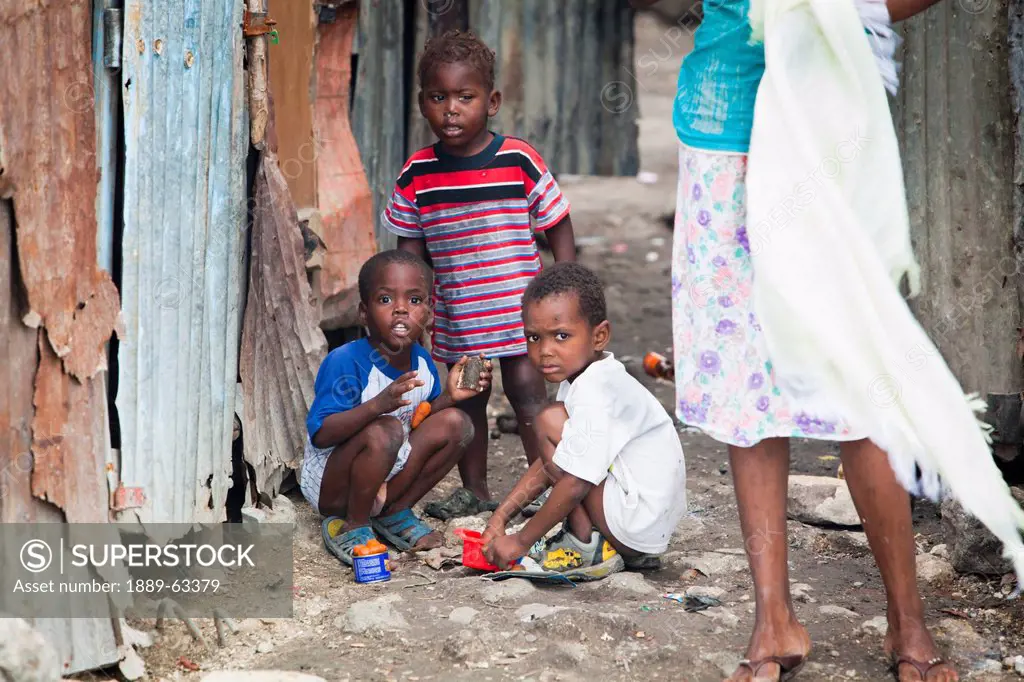 a woman standing with three young boys as they play outside, port_au_prince, haiti