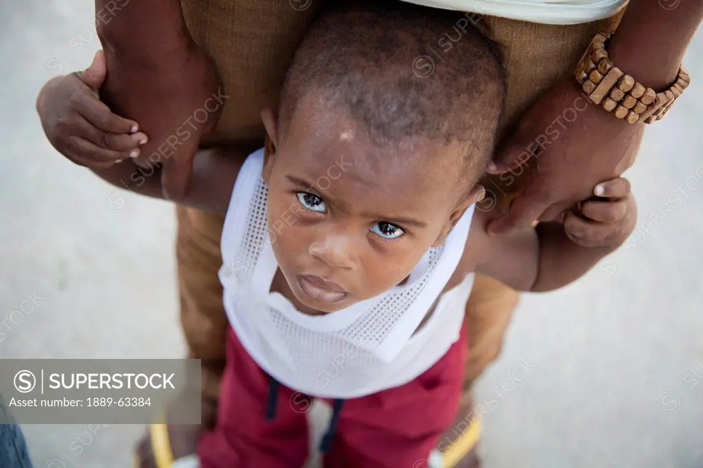 a young boy holding on to his mother´s hands, grand saline, haiti