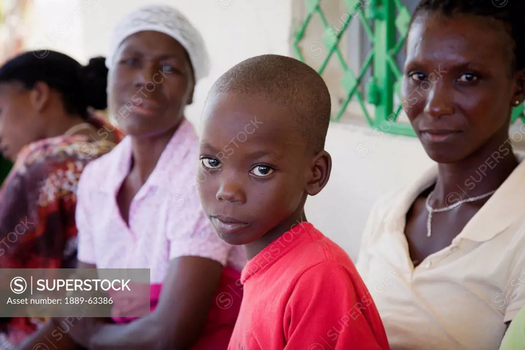 a boy and women waiting at hope alive clinic, grand saline, haiti