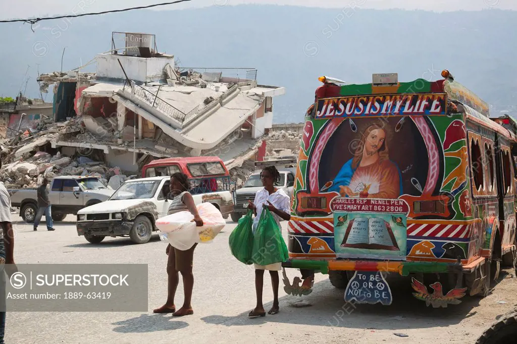 people standing in the street amongst the ruins with a bus reading ´jesus is my life´, port_au_prince, haiti