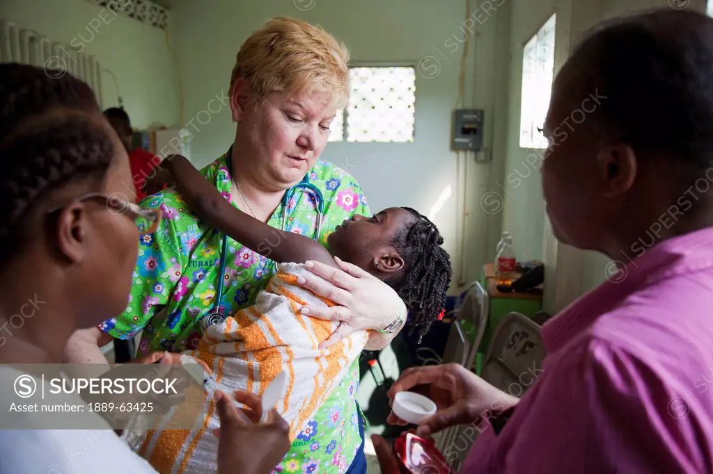 a volunteer nurse cares for a child that suffers from seizures, grand saline, haiti