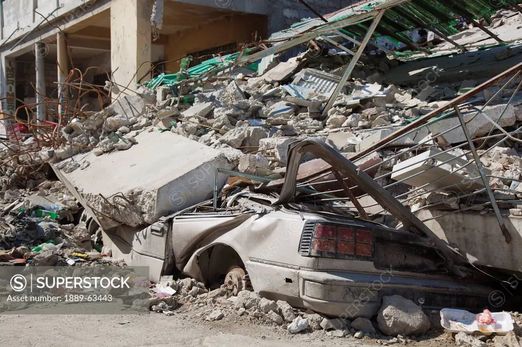 a vehicle is crushed under a collapsed building after an earthquake, port_au_prince, haiti
