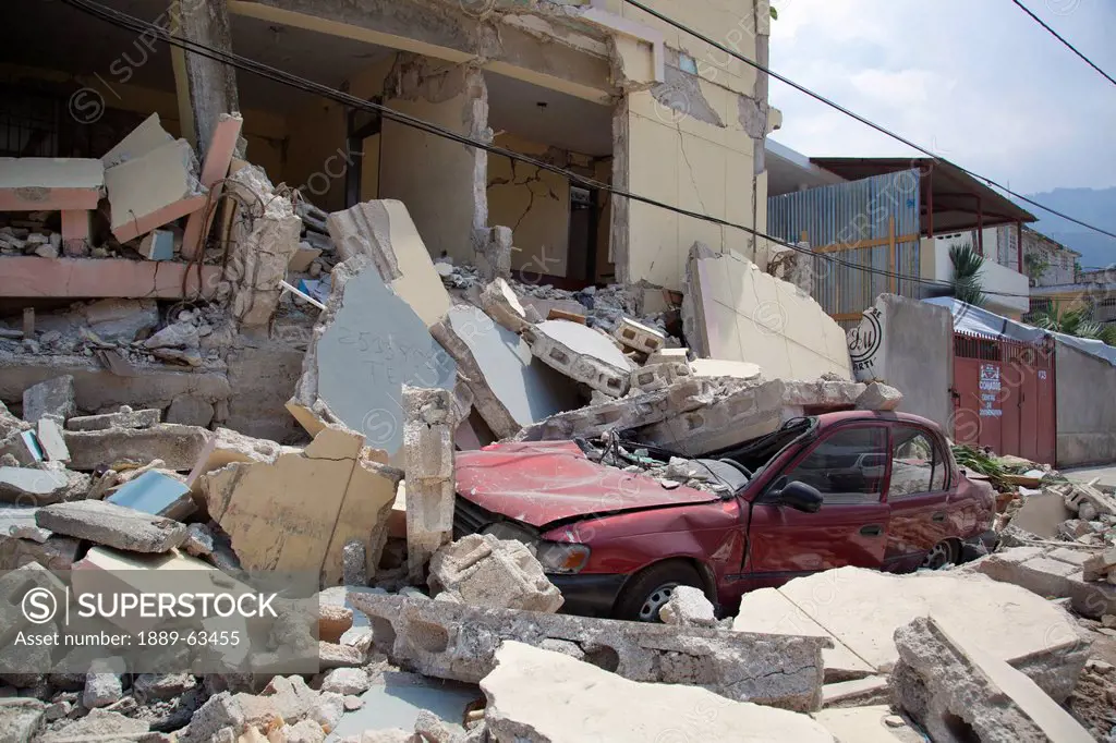 a car is crushed when a building collapses after the earthquake, port_au_prince, haiti