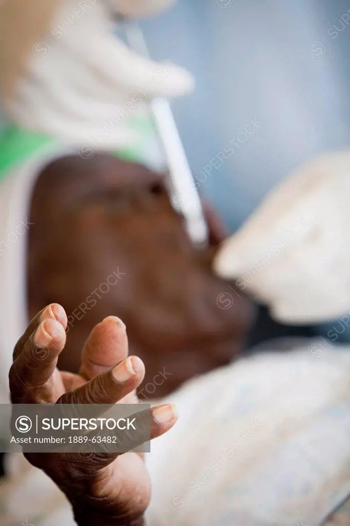 a hand of a patient reaches out as they are being treated at the hope alive clinic, grand saline, haiti