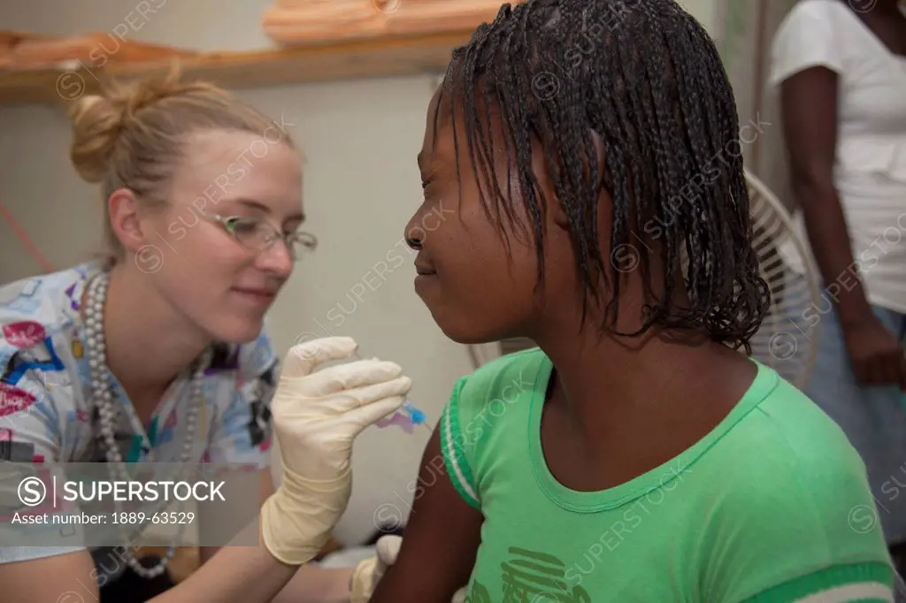 a nurse gives a vaccination at a clinic, grand saline, haiti