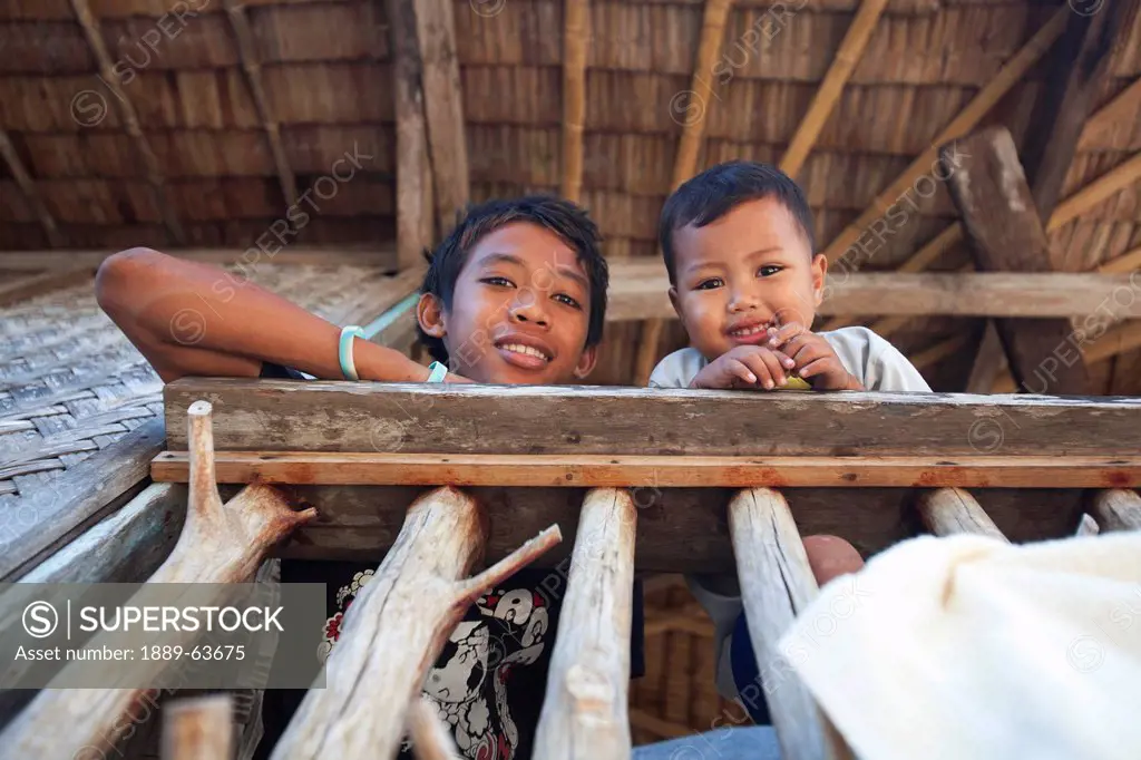 two children smile in the remote and tiny fishing village of vigan near snake island and el nido, vigan, bacuit archipelago, palawan, philippines