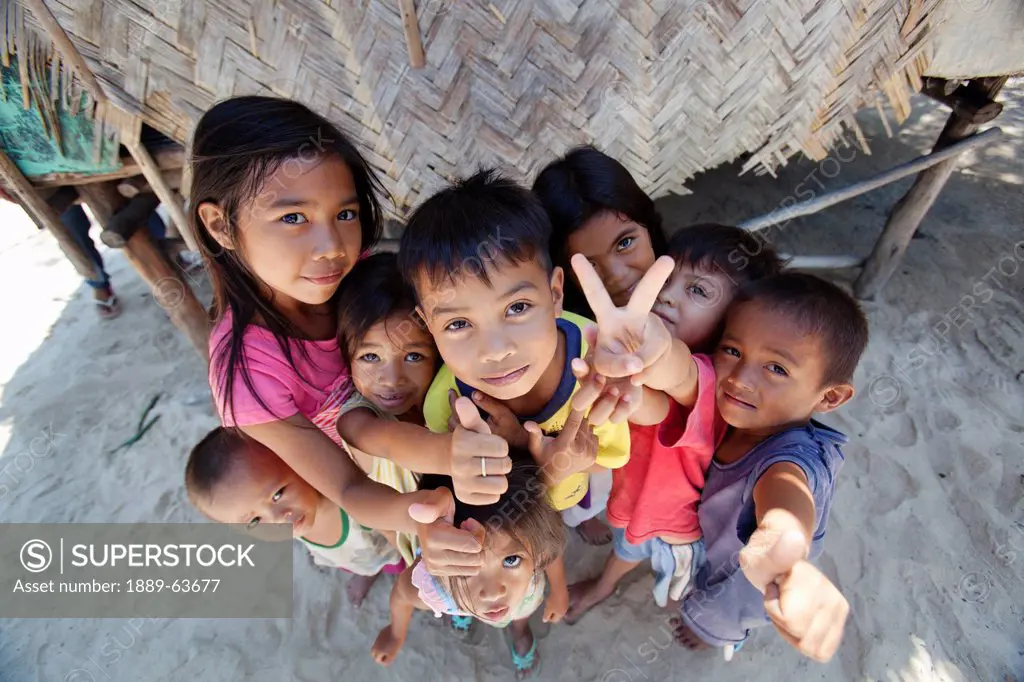 a group of children pose for the camera in the tiny fishing village of vigan near snake island and el nido, vigan, bacuit archipelago, palawan, philip...