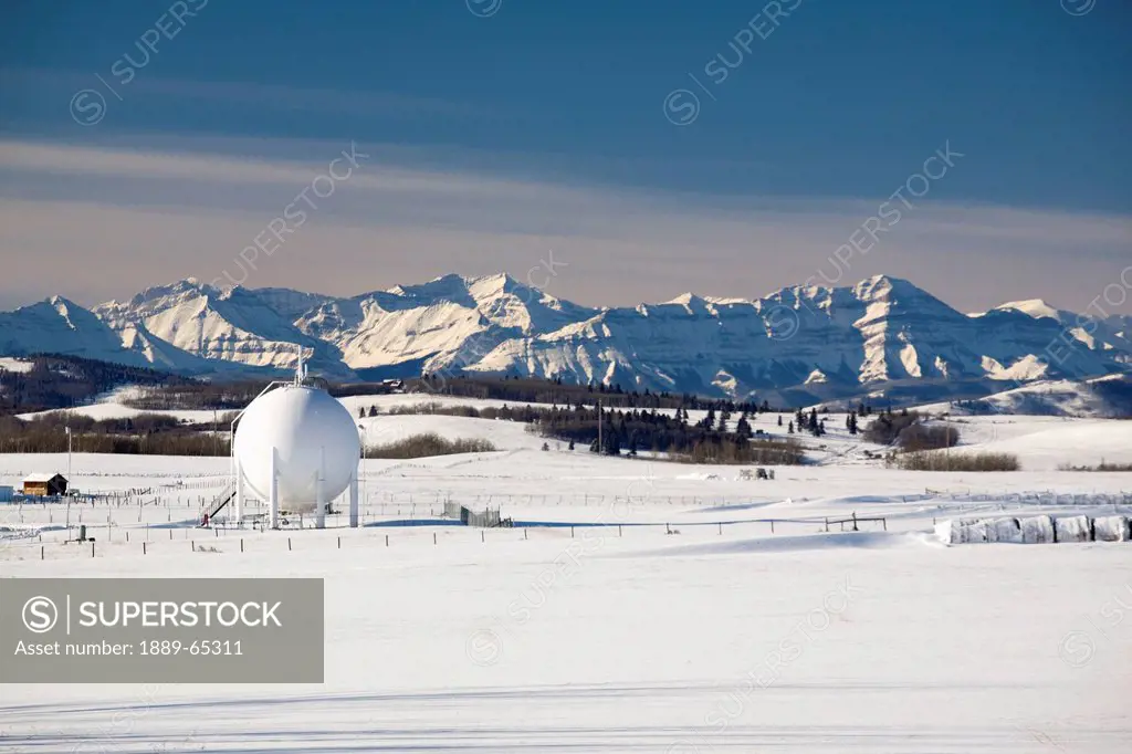 spherical oil tank in a snow_covered field, longview, alberta, canada