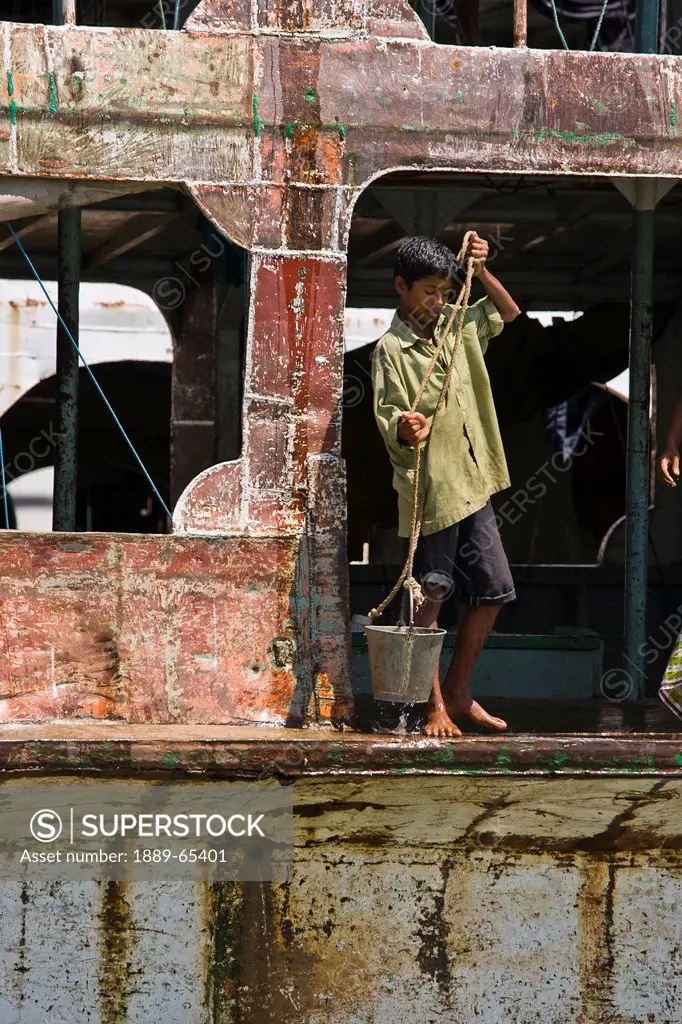 Boy Dips Pail Into Buriganga River From Boat, Dhaka, Bangladesh