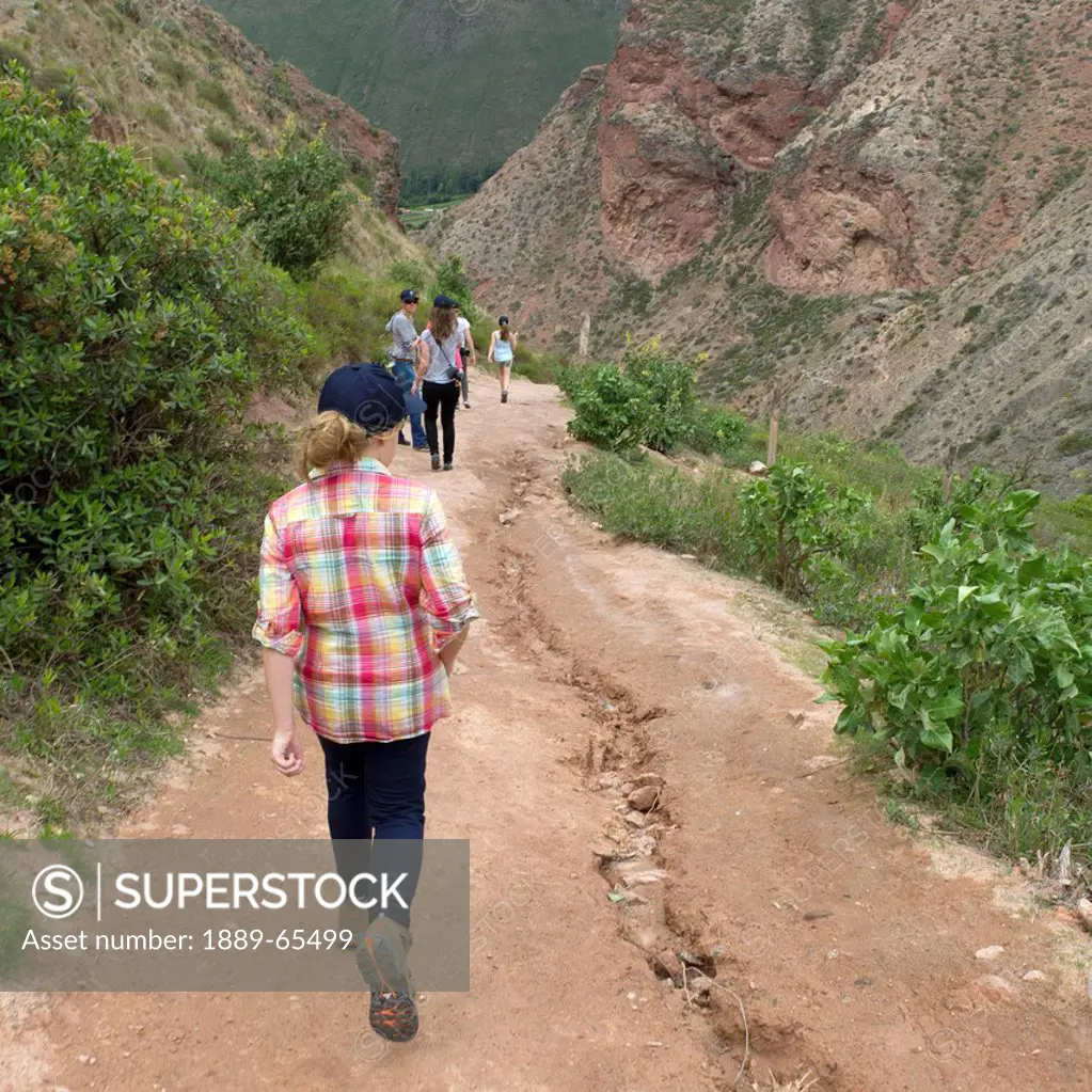 people walking on a path in sacred valley, maras peru