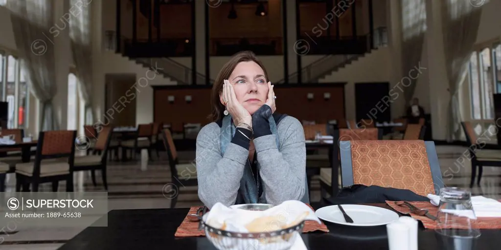 a woman sitting at a restaurant table at the taj hotel, thimphu thimphu district bhutan