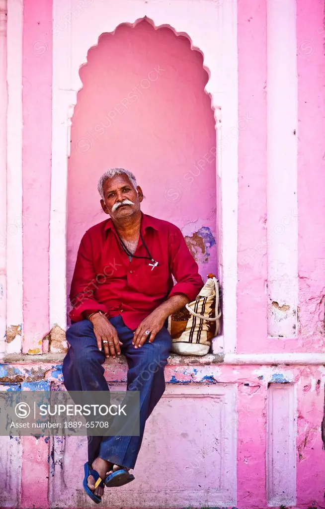 A Man Sits In A Small Alcove In The Side Of A Building, Haridwar India