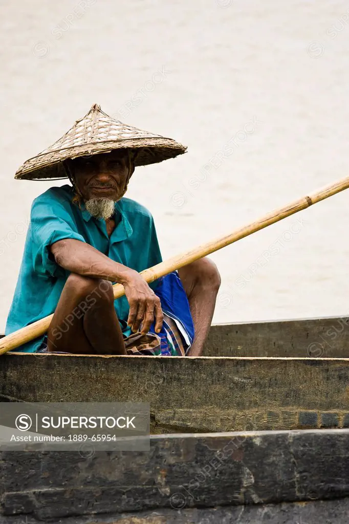 A Man Sitting In A Boat In The Surma River In A Rural Area Near Sylhet, Bangladesh