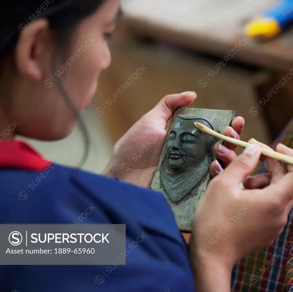 A Woman Works On A Sculpture Of A Human Face, Thimphu Thimphu District Bhutan