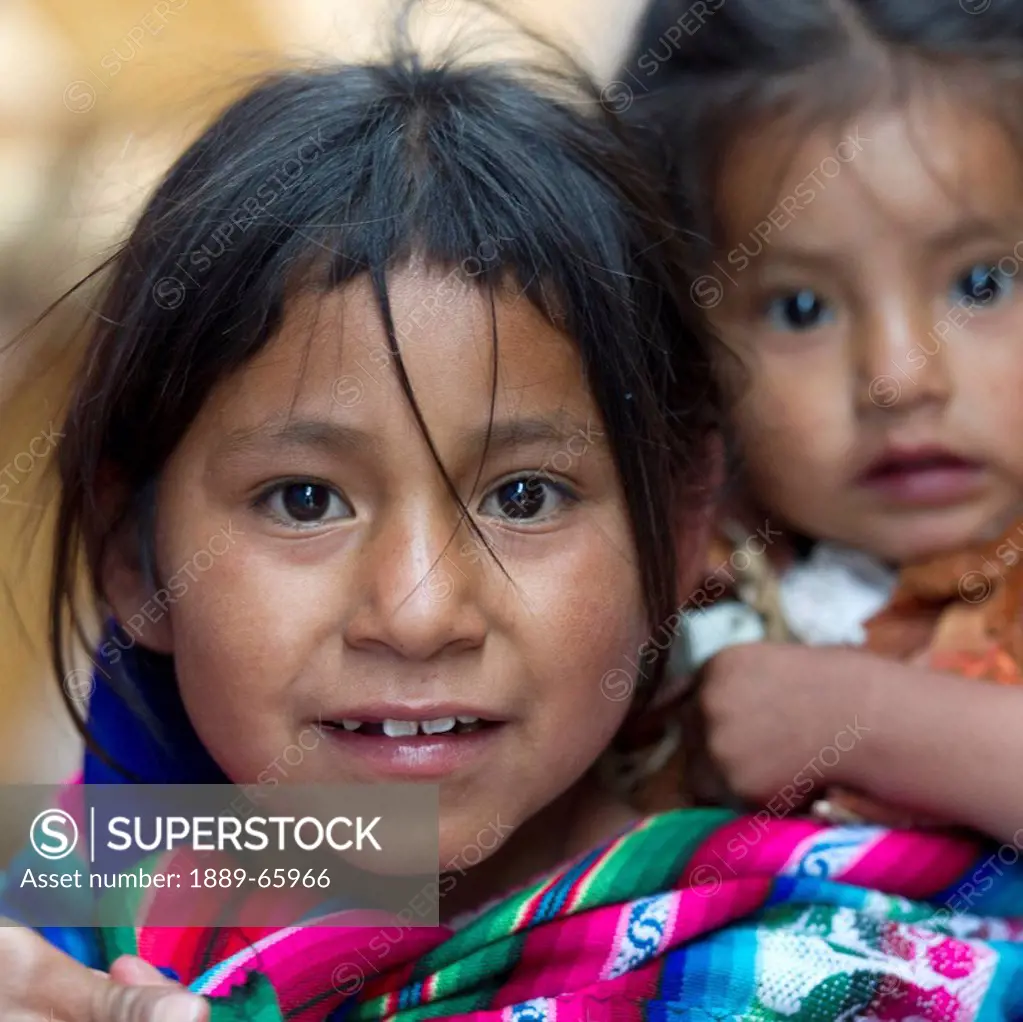 Portrait Of A Girl Carrying A Younger Girl On Her Back, Cusco Peru