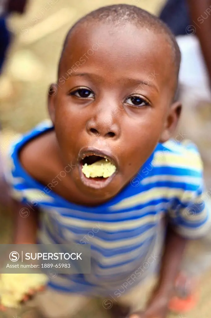 Young Ugandan Child With Food On His Tongue, Kampala Uganda Africa