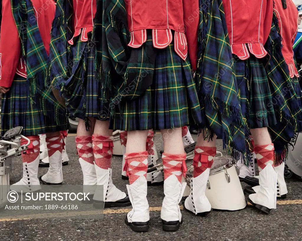 a group of people wearing kilts red jackets and white boots for a parade, victoria british columbia canada