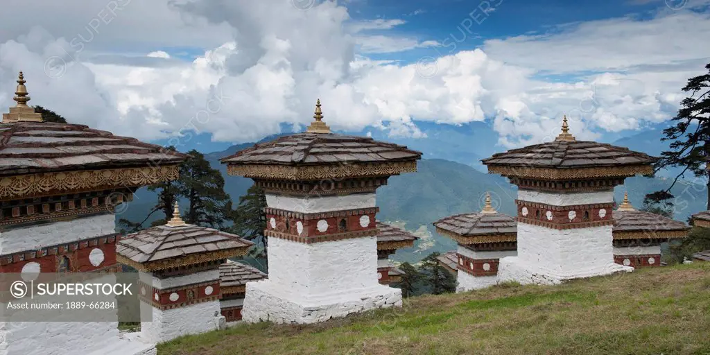white ornate pillars on the side of a mountain, thimphu district bhutan