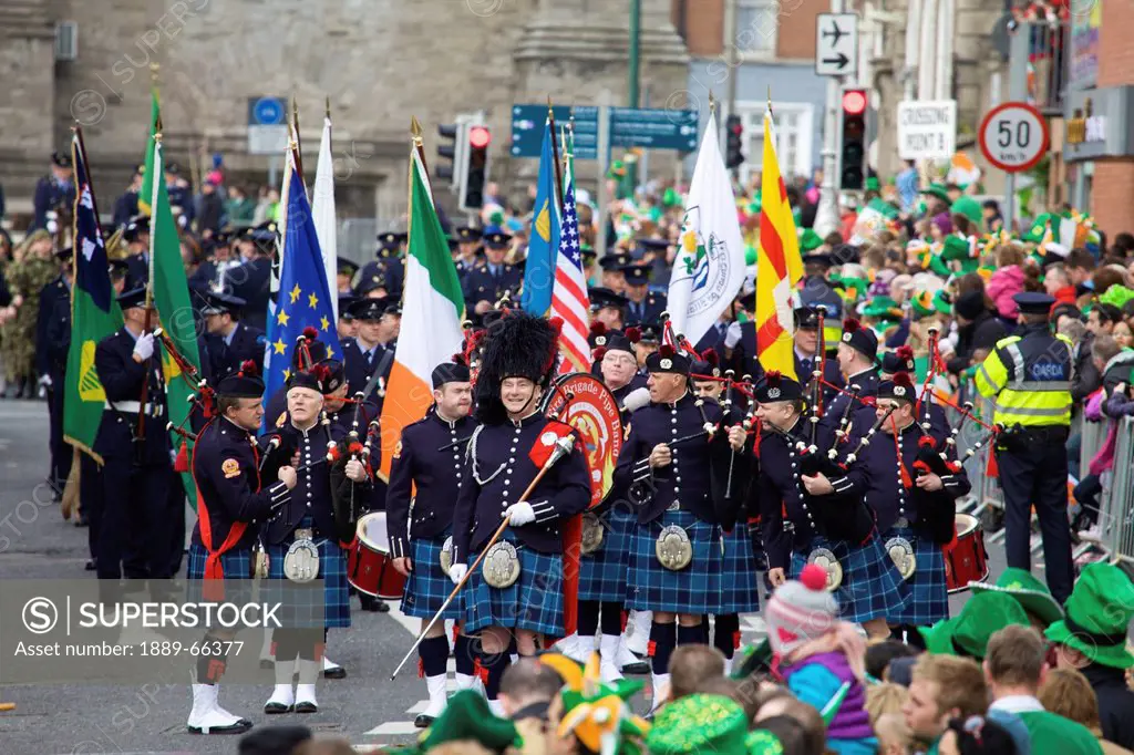 a scottish group wearing kilts and carrying flags for the saint patrick´s day parade, dublin ireland