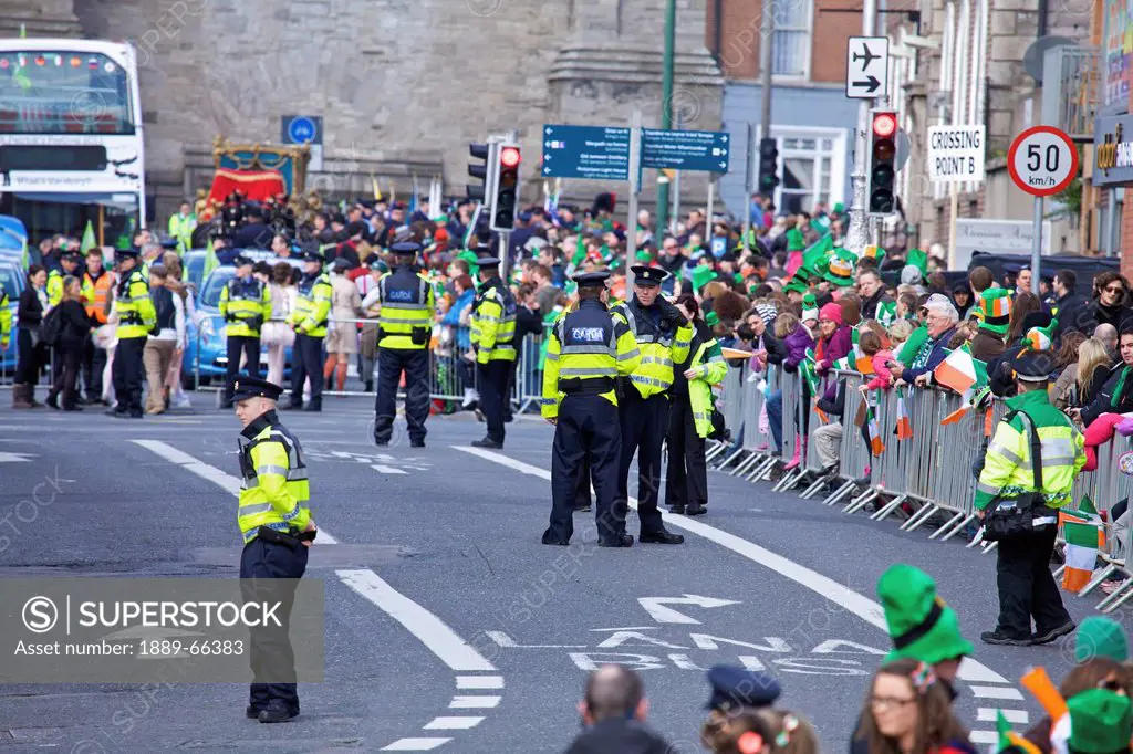 police and a crowd in the street for the saint patrick´s day parade, dublin ireland