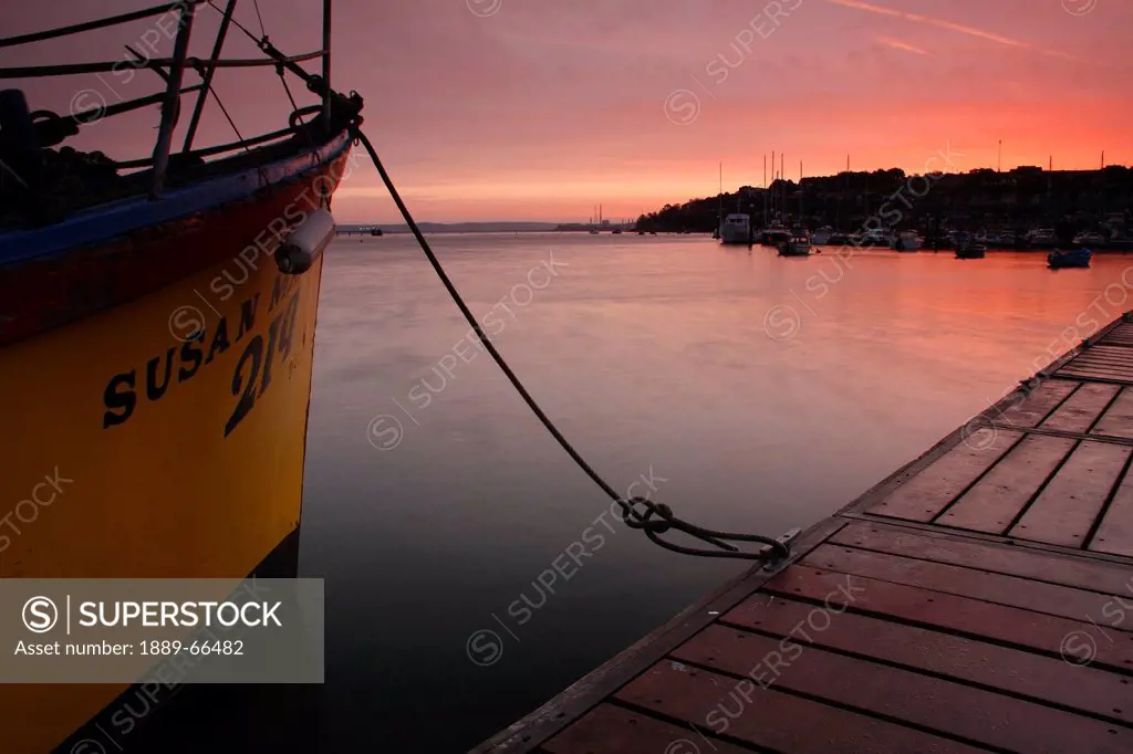 boat moored beside harbor pier at sunrise, crosshaven county cork ireland