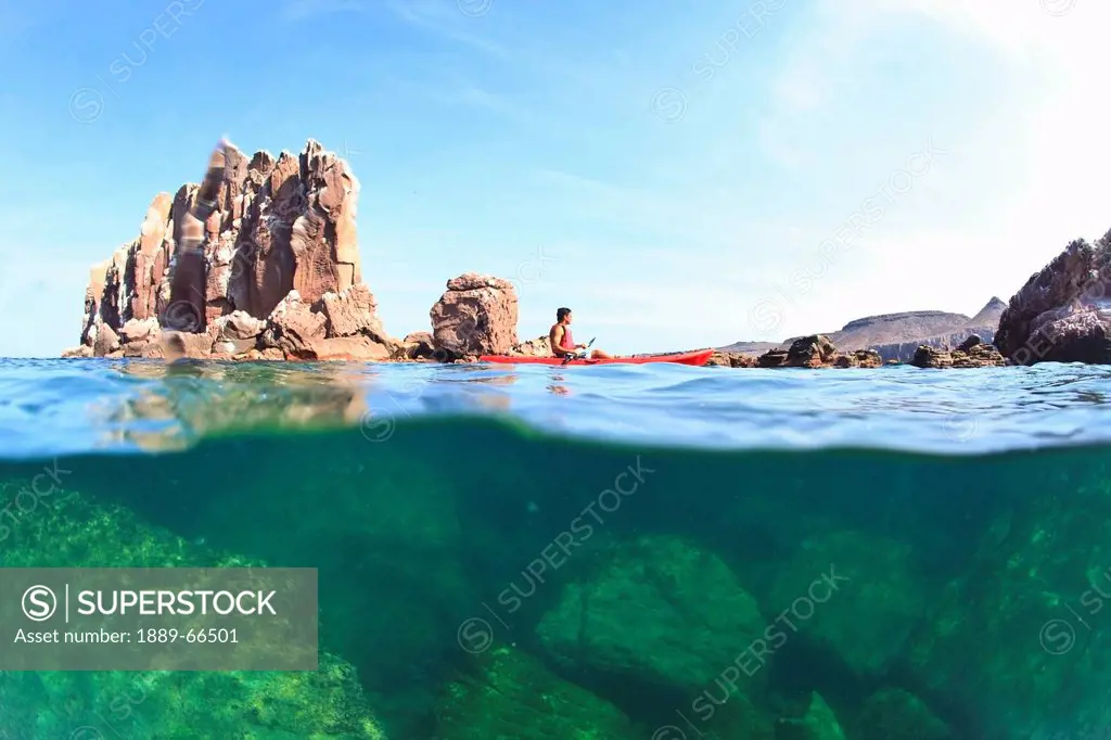 a tourist paddles a boat in los islotes national marine park by espiritu santo island, la paz baja california mexico