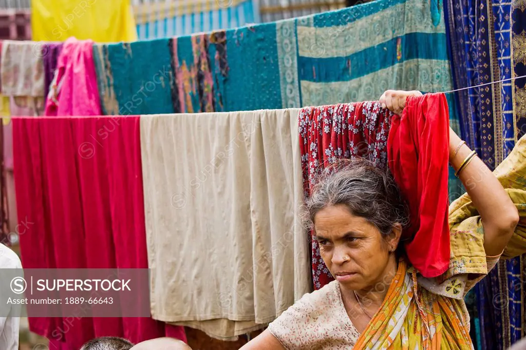 A Woman Hangs Fabric On A Line In The Slums, Sylhet, Bangladesh