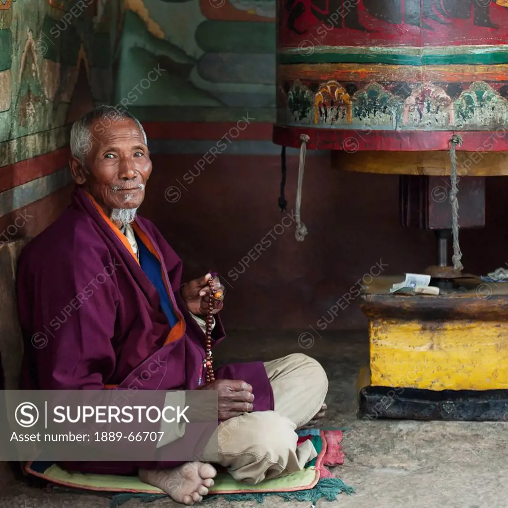 Senior Male Praying At Chimi Lhakhang Monastery, Punakha District Bhutan