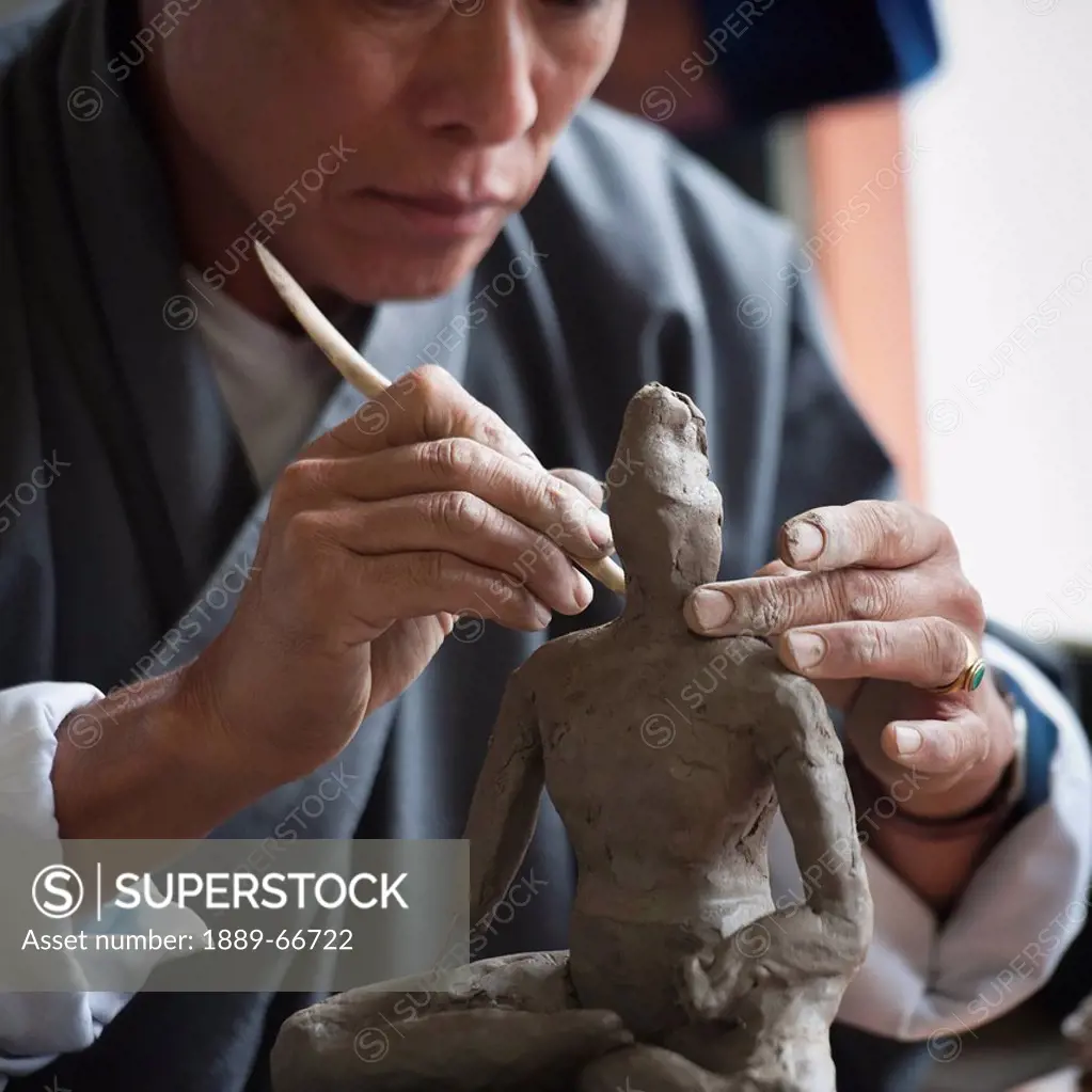 Art Student Sculpting A Clay Figure In National Institute Of Zorig Chusum, Thimphu Bhutan