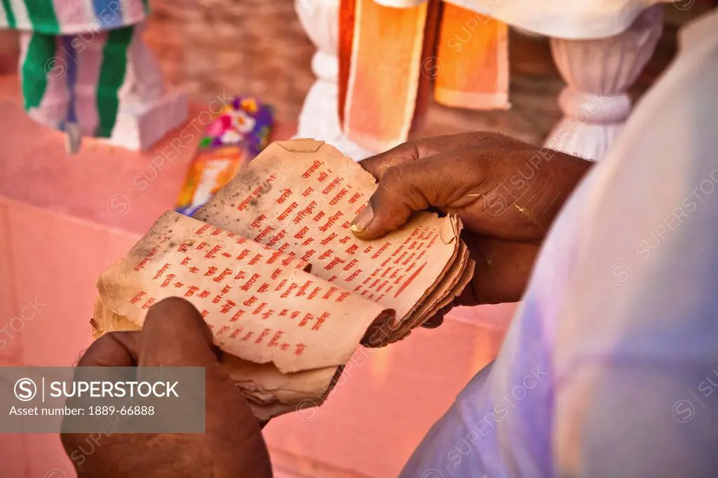 A Man Holds Paper With Red Text Reading In Worship, Haridwar India