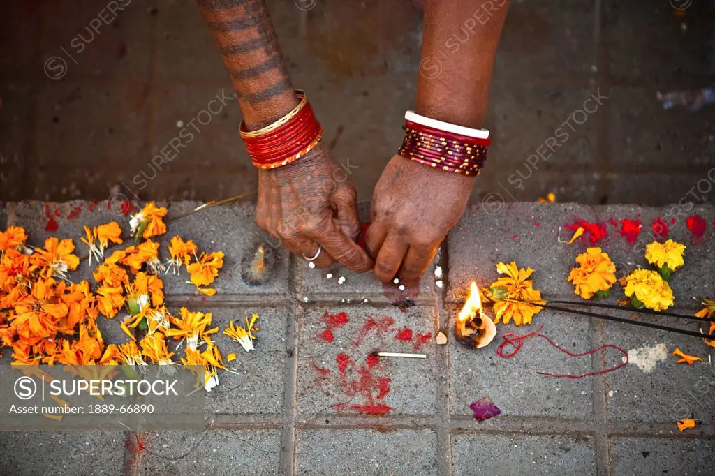 A Woman Performs A Hindu Ritual With Marigold Flowers, Haridwar India