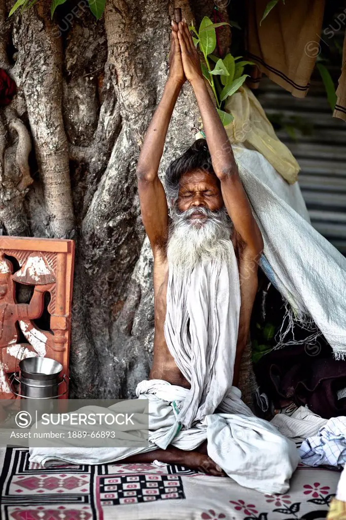 A Holy Man Sits With Eyes Closed And Arms Raised, Haridwar India