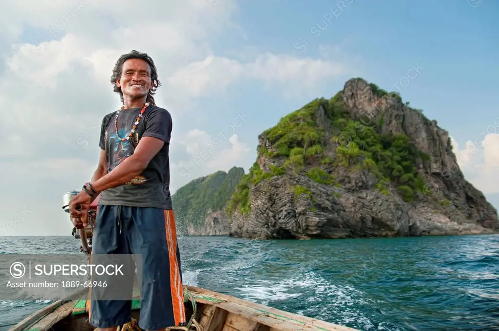 man driving a boat at mosquito island off phi phi islands, phuket thailand